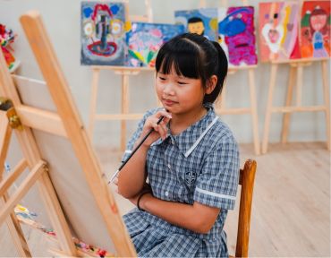 Student painting at an easel